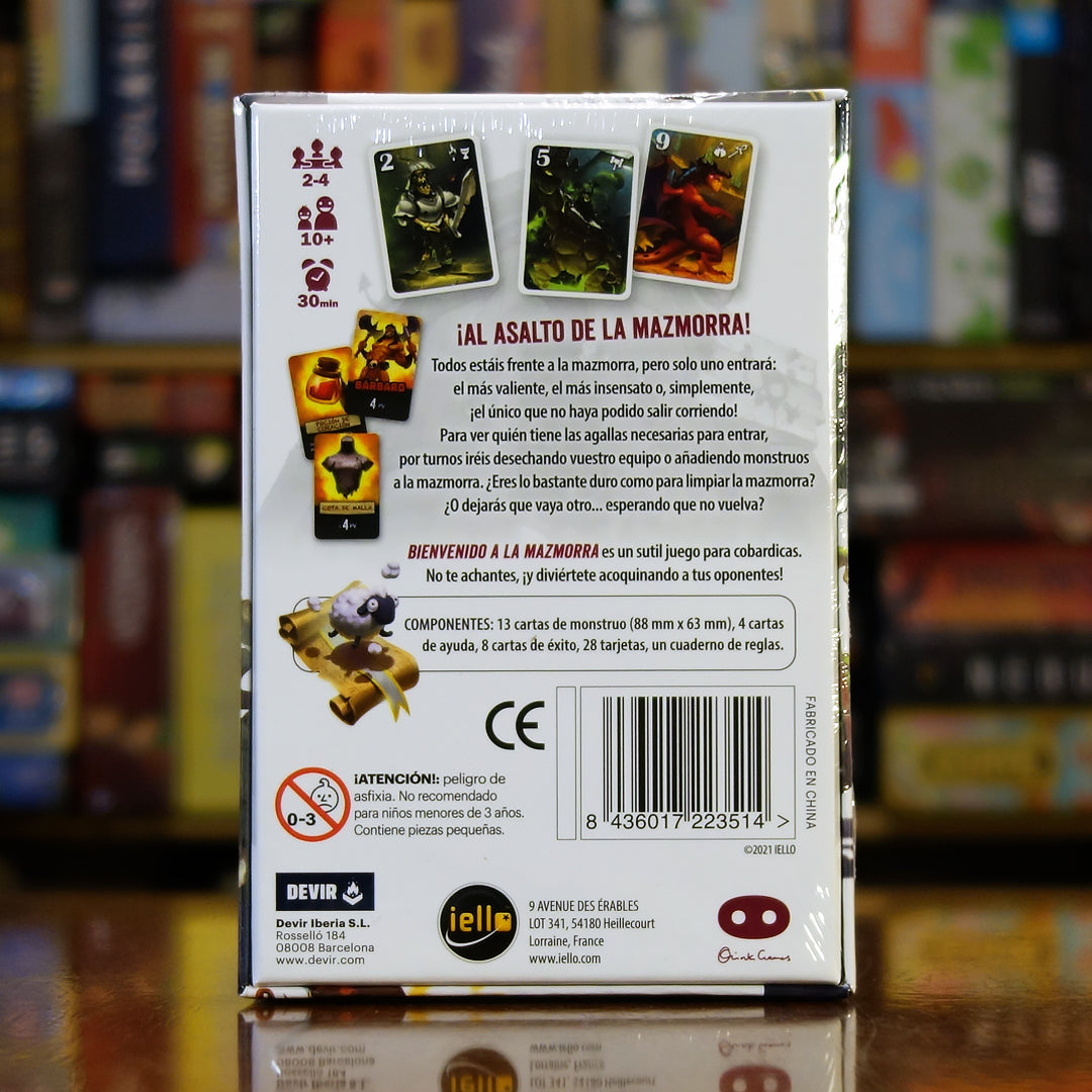 Trasera del juego 'Bienvenido a la Mazmorra' (versión IELLO) disponible en Mana House – Juego de 2 a 4 jugadores con mecánica de apuesta y eliminación de equipo. Rondas de tensión y decisiones arriesgadas en cada partida. Welcome to The Dungeon