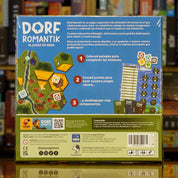 Trasera del juego 'Dorfromantik – El Juego de Mesa' disponible en Mana House – Construcción de paisajes, Campaña rejugable, Fichas ocultas desbloqueables, Hasta 6 jugadores, Inspirado en el éxito indie de Toukana Interactive. Dorfromantik: The Board Game