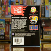 Trasera del juego de mesa 'Dumb Ways to Die' disponible en Mana House - Contenido, Componentes, Reglas, Humor, Fiesta.