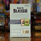 Trasera de la expansión 'Here to Slay: Here to Sleigh' disponible en Mana House - Nuevos Tipos de Carta, Marcos Festivos, Condición de Victoria, Regalos, Líderes de Equipo.