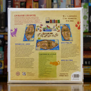 Trasera del juego 'La Isla de los Gatos' disponible en Mana House – Mecánica de poliominós, Cumplimiento de cartas de Manuscrito, Formación de familias de gatos, Gestión del espacio en el barco, Ambientación de aventura y rescate. The Isle of Cats