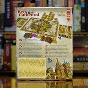 Trasera del juego 'The Red Cathedral' disponible en Mana House – Juego de colocación y gestión de recursos, Rondel de dados, Competencia por secciones de catedral, Decoraciones, Puntos de prestigio, Ideal para amantes de la optimización.